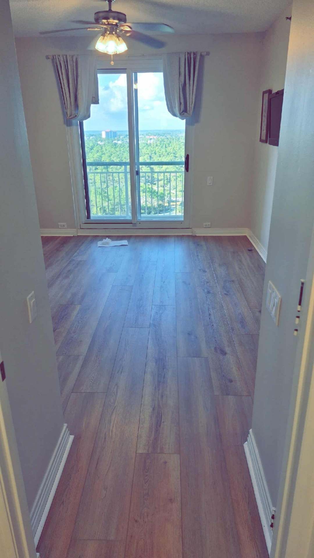 Bright bedroom Flooring Installation with balcony access and luxury vinyl flooring in Pensacola
