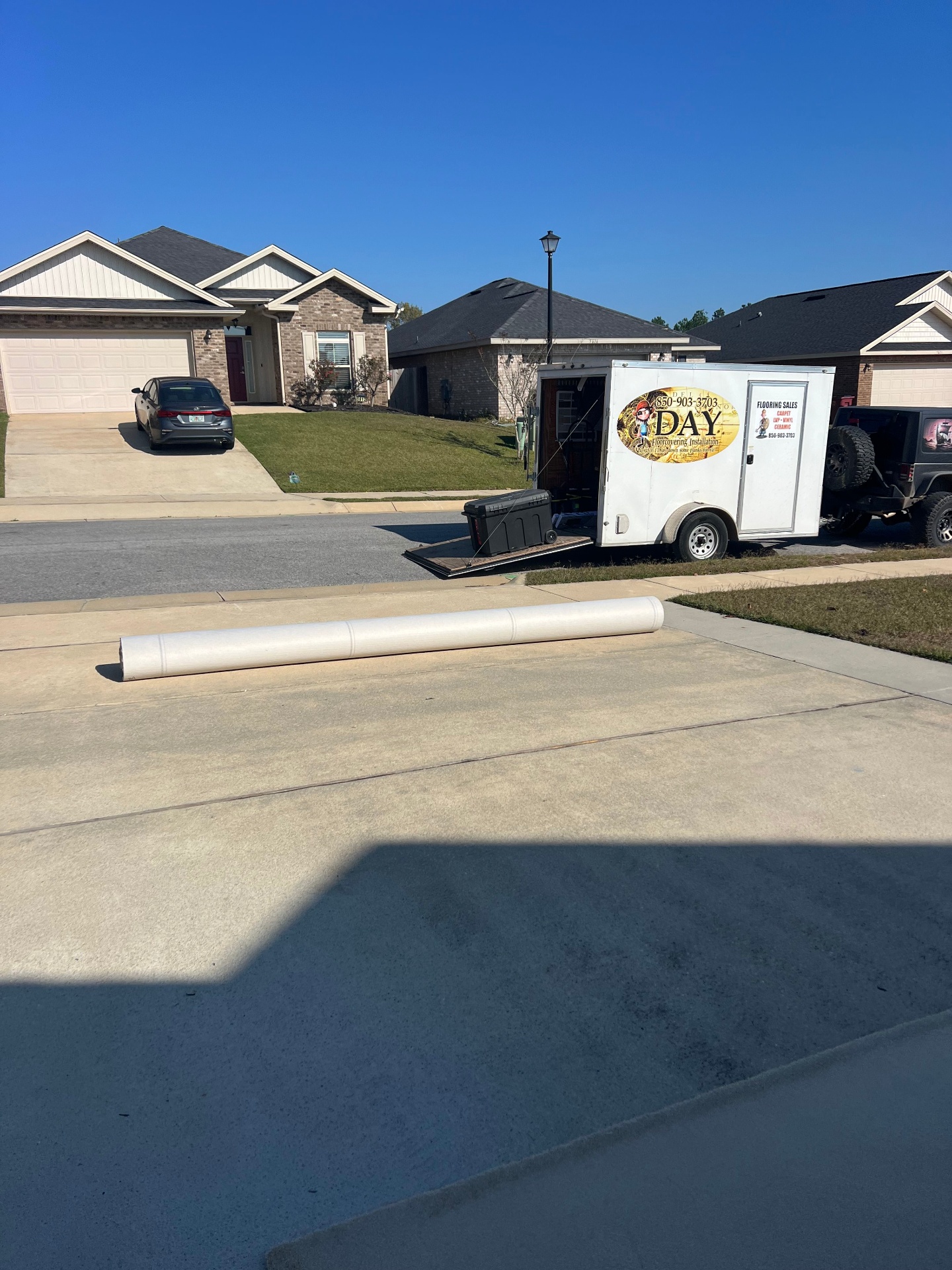 Professional flooring installation trailer and equipment on-site in Brent